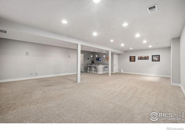 finished basement with recessed lighting, light carpet, and baseboards