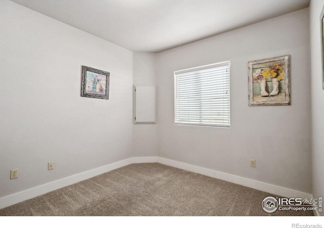 spare room featuring carpet floors and baseboards