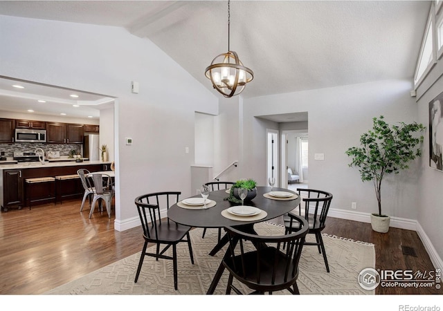 dining room featuring wood finished floors, beamed ceiling, a chandelier, baseboards, and recessed lighting