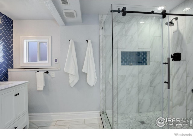bathroom with a stall shower, vanity, and marble look tile flooring