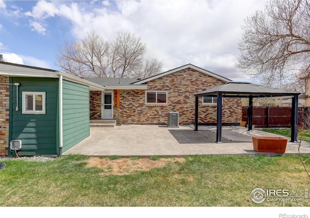 rear view of house featuring a gazebo, a patio area, central AC unit, and brick siding