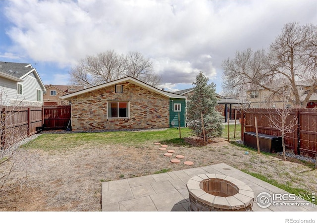 back of house with brick siding, a fire pit, and a patio area