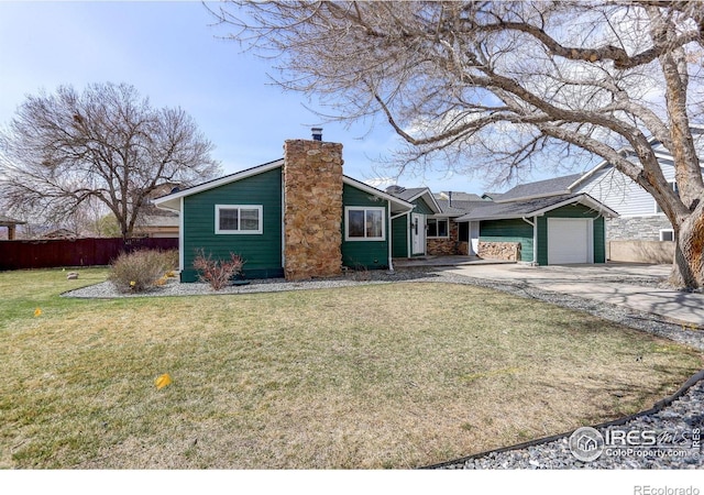 mid-century modern home with a garage, a chimney, and driveway