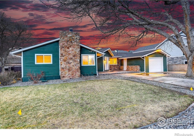 319 Carter Ln, Longmont, CO 80501 - view of front of property with a garage, a chimney, a yard, and driveway