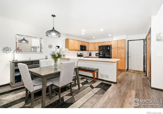 dining area with light wood finished floors, recessed lighting, and baseboards