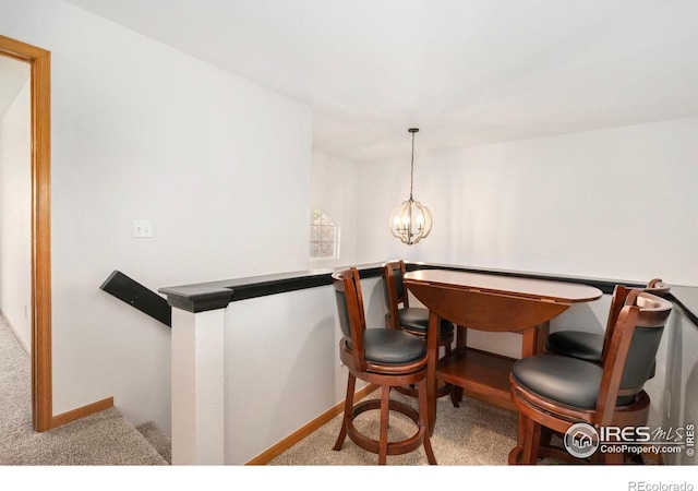dining area with carpet flooring, a chandelier, and baseboards
