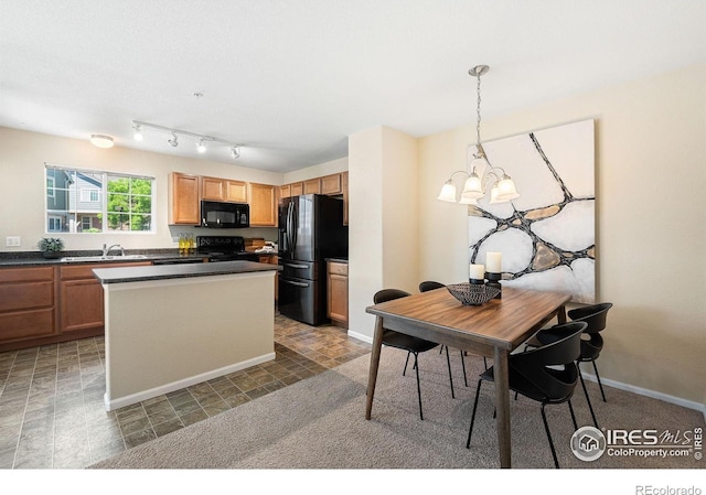 14300 Waterside Ln Unit V1, Broomfield, CO 80023 - kitchen with black appliances, dark countertops, a sink, a kitchen island, and hanging light fixtures