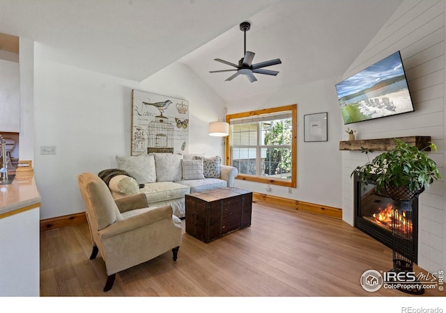 246 Rock Bridge Ln Unit 3, Windsor, CO 80550 - living area with a glass covered fireplace, lofted ceiling, wood finished floors, a ceiling fan, and baseboards