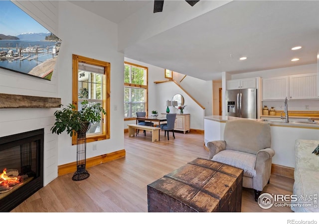 246 Rock Bridge Ln Unit 3, Windsor, CO 80550 - living room featuring light wood-type flooring, a glass covered fireplace, baseboards, recessed lighting, and stairs