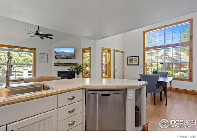 246 Rock Bridge Ln Unit 3, Windsor, CO 80550 - kitchen featuring stainless steel dishwasher, lofted ceiling, a glass covered fireplace, a sink, and light wood-type flooring