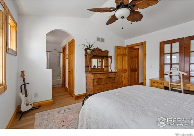 246 Rock Bridge Ln Unit 3, Windsor, CO 80550 - bedroom with arched walkways, light wood finished floors, lofted ceiling, baseboards, and ensuite bath