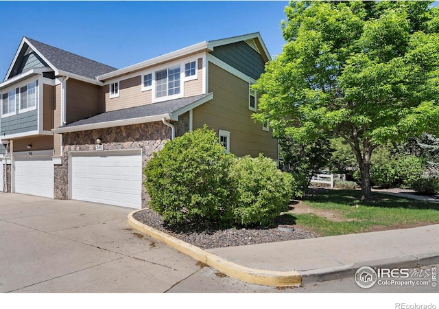 246 Rock Bridge Ln Unit 3, Windsor, CO 80550 - view of home's exterior with stone siding, concrete driveway, and a garage