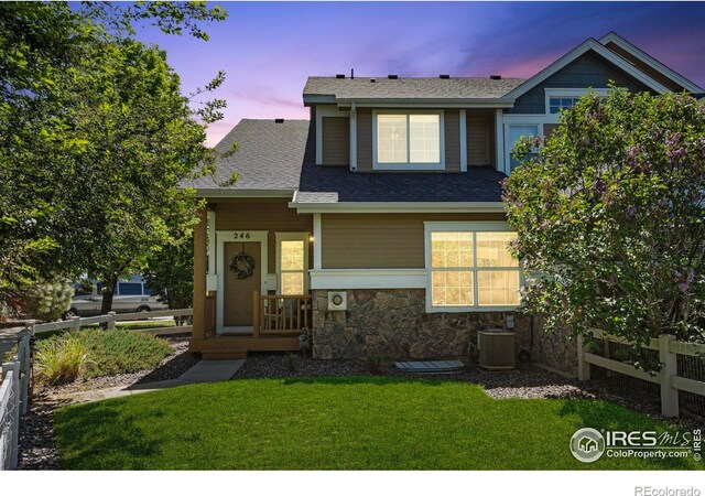 246 Rock Bridge Ln Unit 3, Windsor, CO 80550 - view of front of property with a porch, stone siding, cooling unit, and roof with shingles