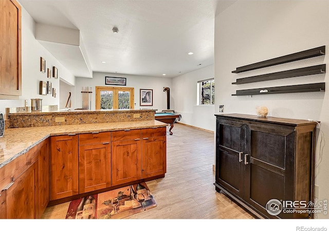 278 Clark Rd, Bailey, CO 80421 - kitchen with light wood-style floors, a peninsula, light stone counters, french doors, and brown cabinetry