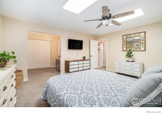 bedroom with a skylight, carpet, a closet, and baseboards