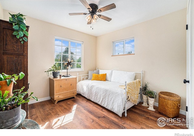 bedroom featuring wood finished floors, baseboards, and a ceiling fan