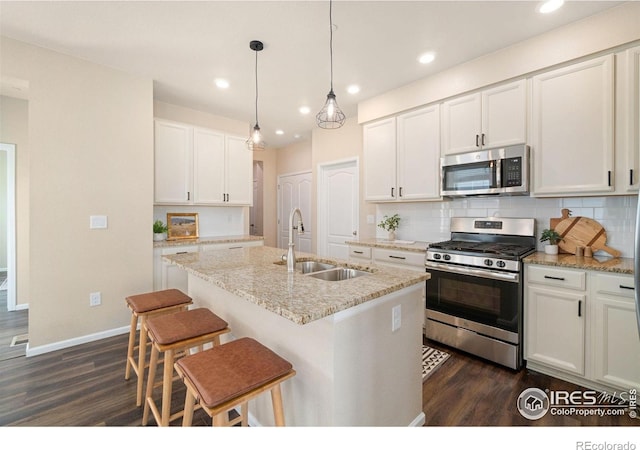 214 Tigercat Way, Fort Collins, CO 80524 - kitchen featuring appliances with stainless steel finishes, a sink, dark wood-style floors, decorative backsplash, and baseboards