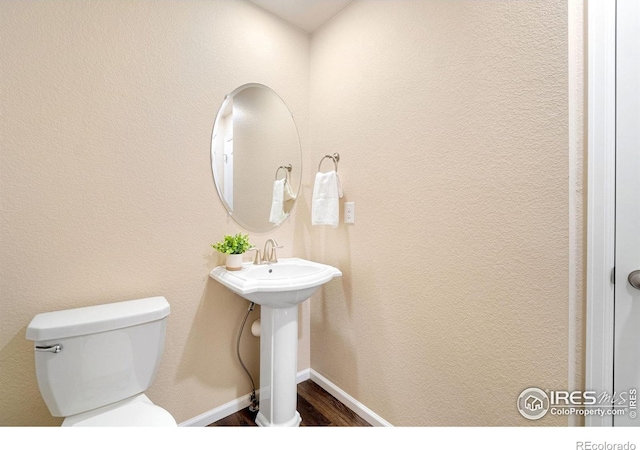 214 Tigercat Way, Fort Collins, CO 80524 - bathroom featuring toilet, wood finished floors, and baseboards