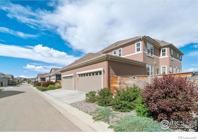 214 Tigercat Way, Fort Collins, CO 80524 - view of property exterior featuring driveway, fence, and a garage