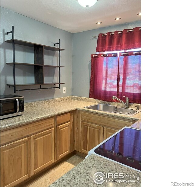 210 S Bowman Ave, Holyoke, CO 80734 - kitchen featuring stainless steel microwave, a sink, open shelves, light wood finished floors, and white electric range oven