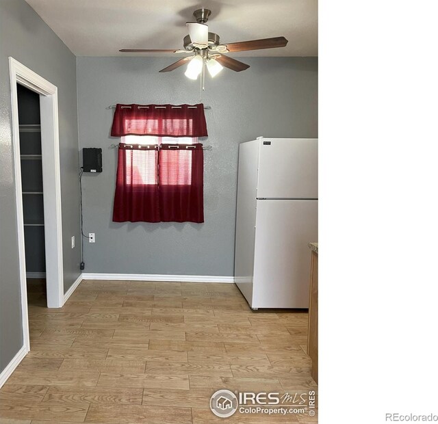 210 S Bowman Ave, Holyoke, CO 80734 - kitchen with freestanding refrigerator, a ceiling fan, baseboards, and light wood-style flooring