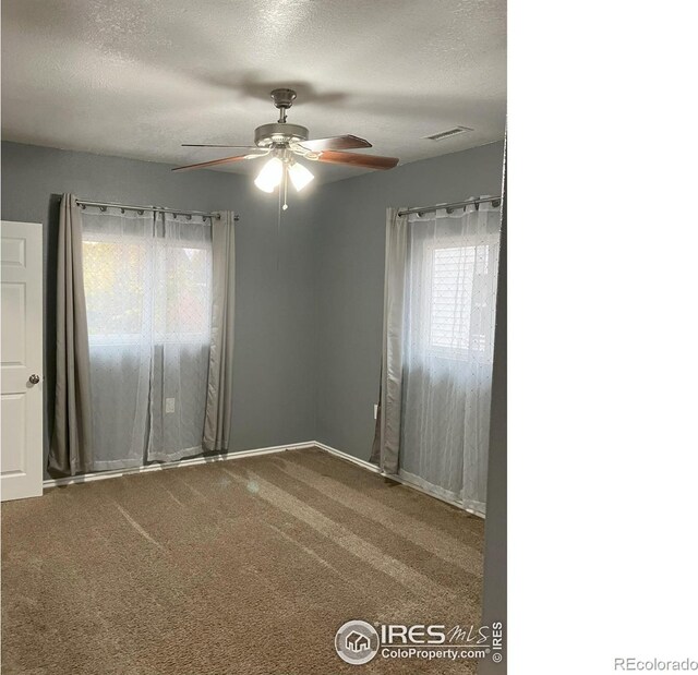 210 S Bowman Ave, Holyoke, CO 80734 - spare room featuring a ceiling fan, a textured ceiling, baseboards, and carpet flooring