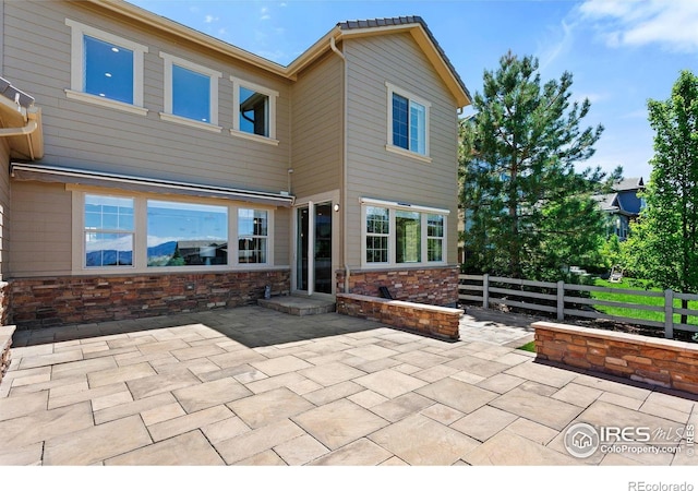 16069 Pikes Peak Dr, Broomfield, CO 80023 - back of property with a patio area, fence, and stone siding