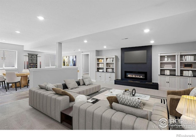 16069 Pikes Peak Dr, Broomfield, CO 80023 - living area featuring recessed lighting, a fireplace, built in features, and wood finished floors