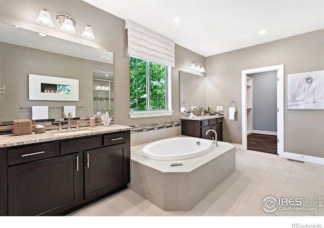 16069 Pikes Peak Dr, Broomfield, CO 80023 - full bath with a garden tub, two vanities, a stall shower, tile patterned floors, and baseboards