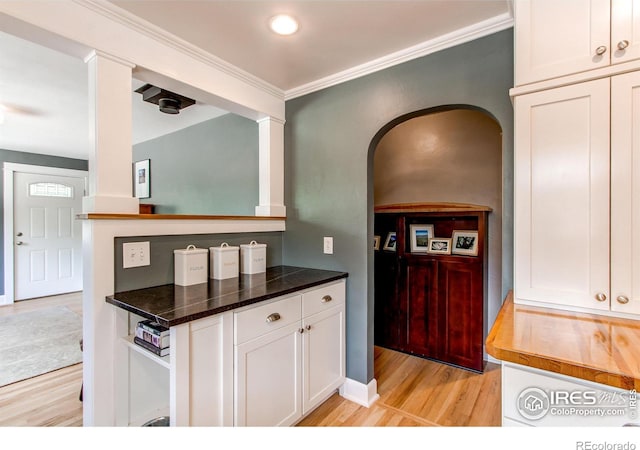 628 Endicott St, Fort Collins, CO 80524 - kitchen with light wood finished floors, white cabinetry, crown molding, and arched walkways
