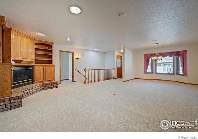 unfurnished living room with a textured ceiling, light carpet, a chandelier, a fireplace, and recessed lighting