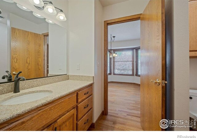 bathroom featuring wood finished floors, vanity, and baseboards