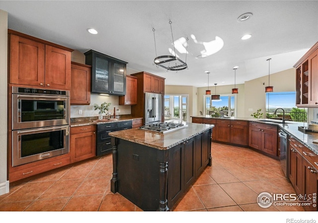 kitchen featuring appliances with stainless steel finishes, a sink, glass insert cabinets, hanging light fixtures, and recessed lighting