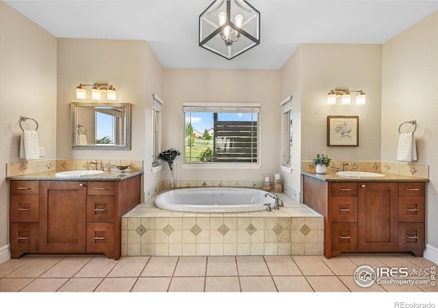 full bathroom with two vanities, tile patterned flooring, a bath, and a chandelier