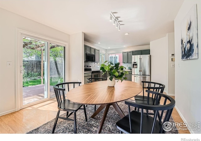 dining room with baseboards, light wood-style flooring, rail lighting, and recessed lighting