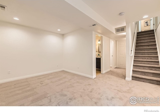 below grade area featuring carpet floors, baseboards, stairs, and recessed lighting