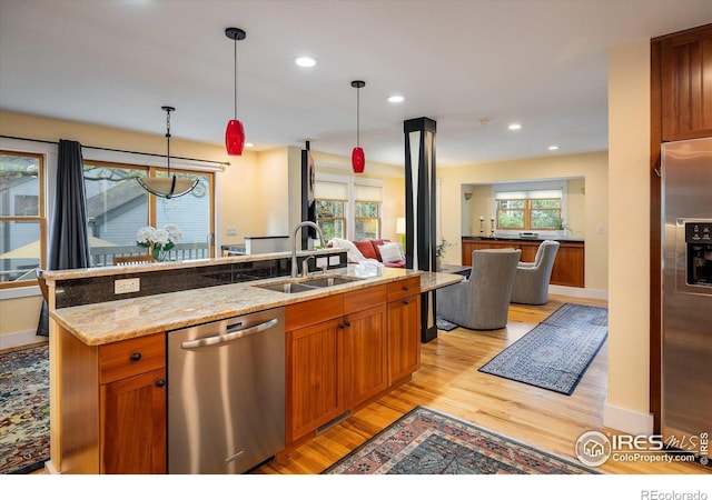 5523 Stonewall Pl, Boulder, CO 80303 - kitchen featuring stainless steel appliances, a sink, light wood-style floors, open floor plan, and hanging light fixtures