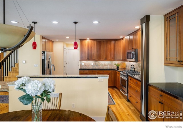 5523 Stonewall Pl, Boulder, CO 80303 - kitchen featuring appliances with stainless steel finishes, light wood-type flooring, tasteful backsplash, recessed lighting, and decorative light fixtures