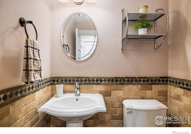 5523 Stonewall Pl, Boulder, CO 80303 - bathroom featuring tile walls, a sink, wainscoting, and toilet