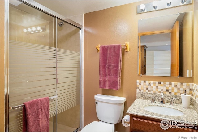 5523 Stonewall Pl, Boulder, CO 80303 - bathroom featuring a shower stall, toilet, vanity, and backsplash