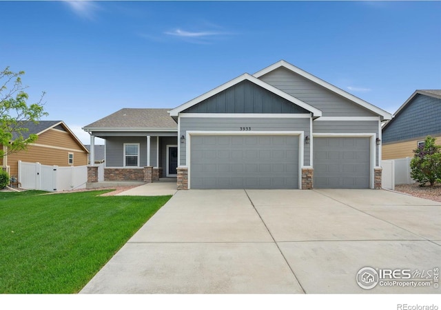 3933 Mount Hope St, Wellington, CO 80549 - view of front facade with an attached garage, concrete driveway, stone siding, and a gate