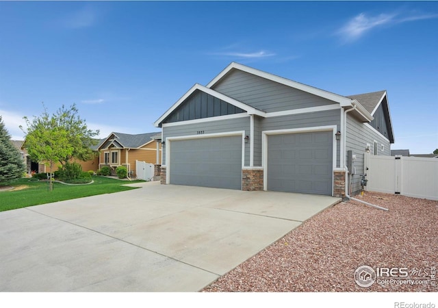3933 Mount Hope St, Wellington, CO 80549 - view of front of house featuring a garage, stone siding, driveway, and board and batten siding