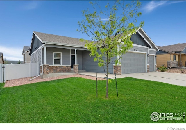 3933 Mount Hope St, Wellington, CO 80549 - view of front of home with stone siding, board and batten siding, driveway, a garage, and a porch