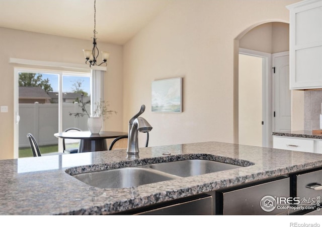 3933 Mount Hope St, Wellington, CO 80549 - kitchen featuring a sink, a chandelier, decorative light fixtures, and white cabinets