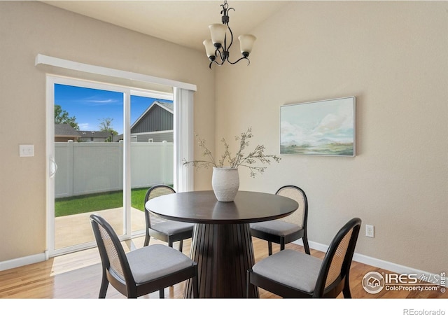 3933 Mount Hope St, Wellington, CO 80549 - dining area featuring a chandelier, light wood-style floors, and baseboards
