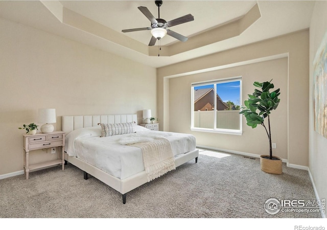 3933 Mount Hope St, Wellington, CO 80549 - carpeted bedroom featuring a raised ceiling, baseboards, and a ceiling fan
