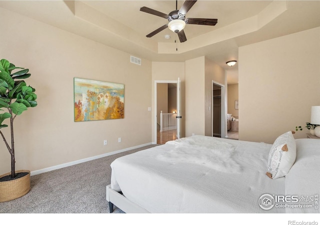 3933 Mount Hope St, Wellington, CO 80549 - carpeted bedroom featuring a tray ceiling, baseboards, and a ceiling fan