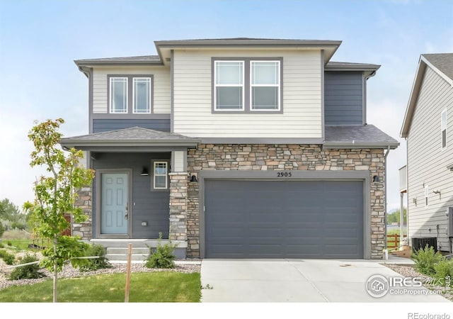prairie-style house featuring stone siding, concrete driveway, an attached garage, cooling unit, and a shingled roof