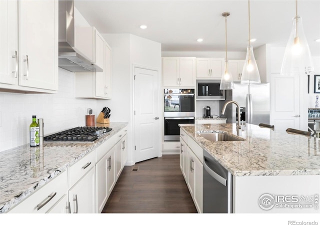 kitchen featuring a sink, wall chimney exhaust hood, stainless steel appliances, dark wood-style flooring, and white cabinets