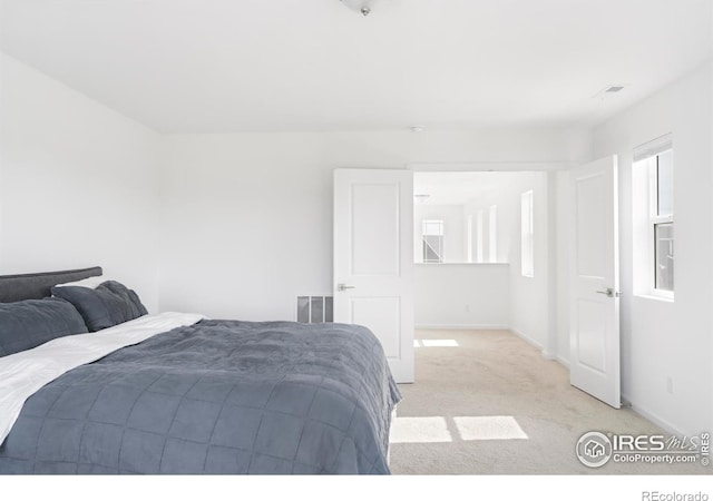 bedroom with baseboards and light carpet